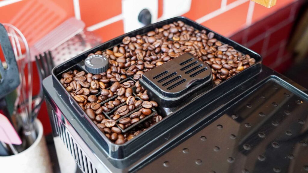Réservoir à grains et molette de mouture d’une machine à café Delonghi Magnifica S, photographiés pendant notre test