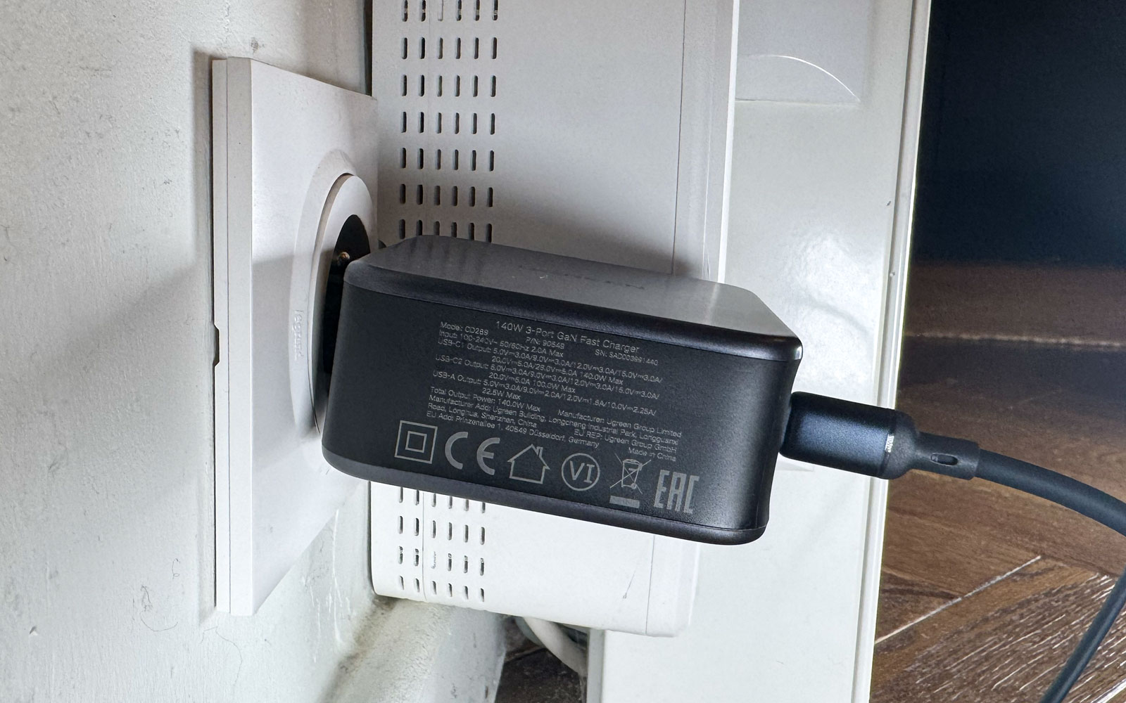 Chargeur Ugreen Nexode 140W GaN branché sur une prise murale en situation réelle.