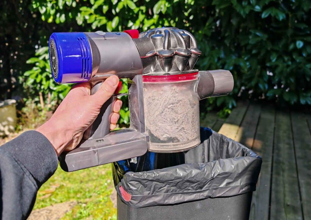 Le Dyson V8 placé au-dessus d’une poubelle, prêt à être vidé. (c) Labo Maison