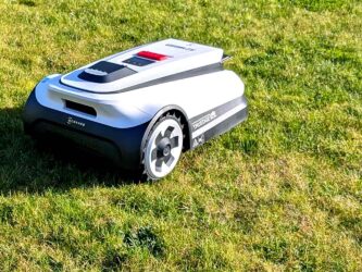 Robot tondeuse sur l'herbe prêt pour changer ses lames pour le printemps 2026