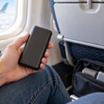 Passager tenant une batterie externe à bord d’un avion