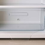 Eau sous le bac à légumes ? Trou bouché, condensation, givre : voici les causes et solutions. (c) Dall.E