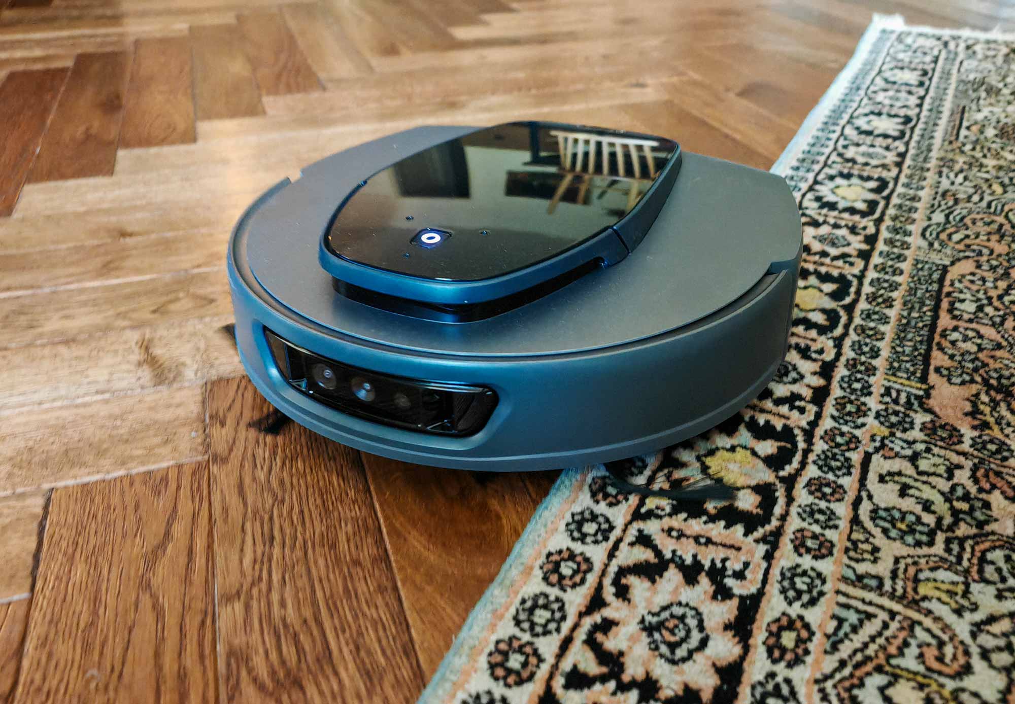 Le robot 3i S10 Ultra en cours de test d’aspiration, entre tapis et parquet.