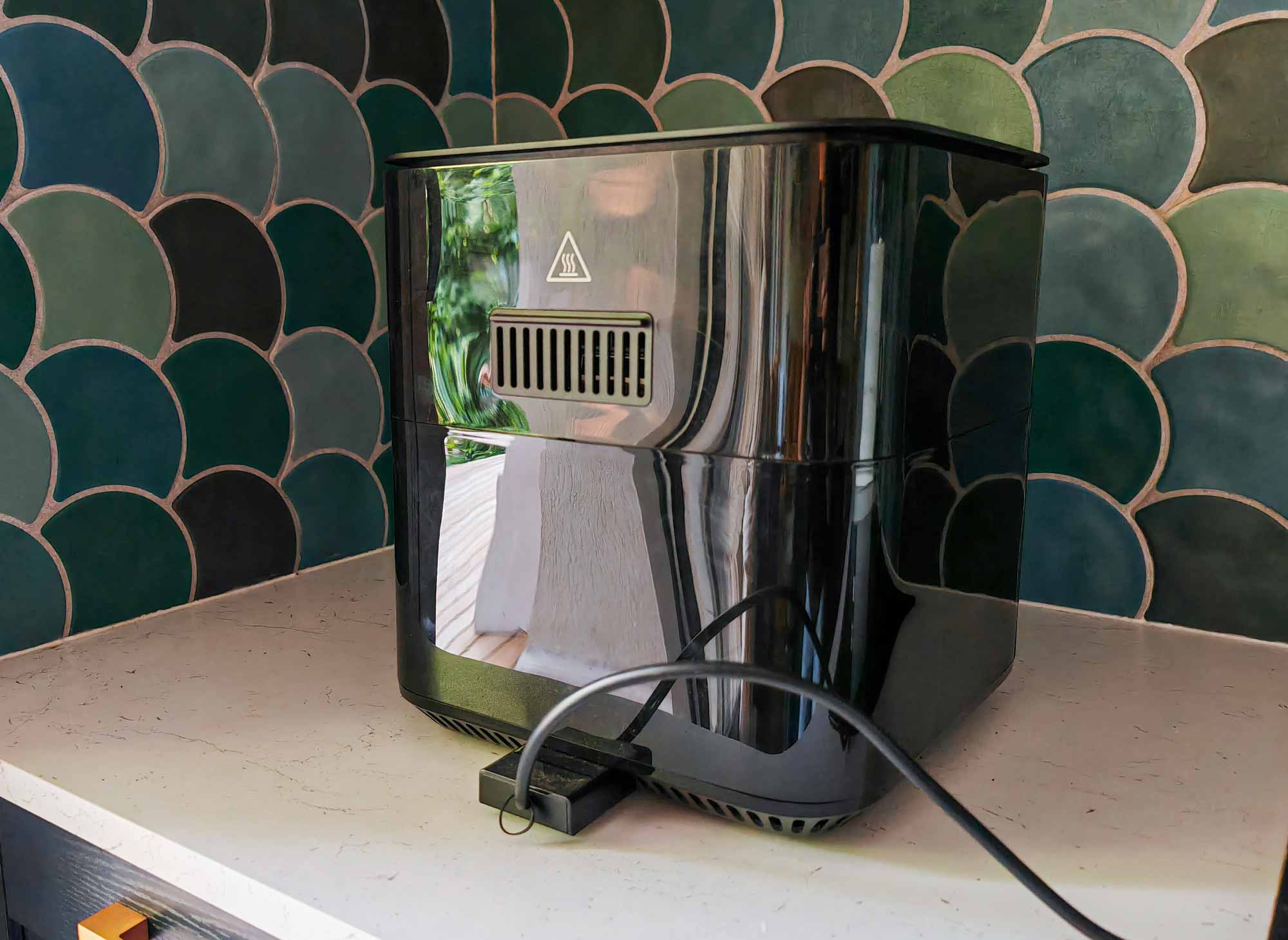 Sortie d’air chaud à l’arrière d’un Air Fryer avec pictogramme de chaleur.