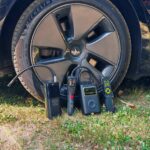 Les quatre compresseurs portatifs au pied d’un pneu de Tesla Model 3 Grande Autonomie, prêts pour le test de gonflage.