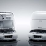 Le robot aspirateur DJI Romo dans sa station, en cours de vidange et de nettoyage