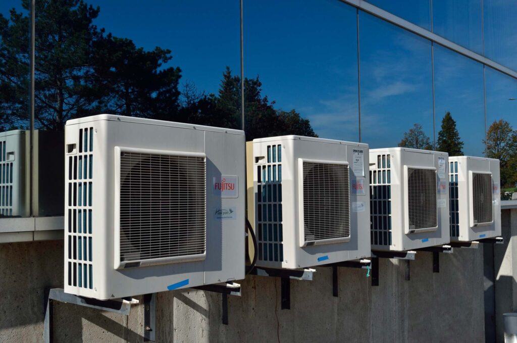 Unités extérieures de climatiseurs fixées à la façade d’un immeuble résidentiel