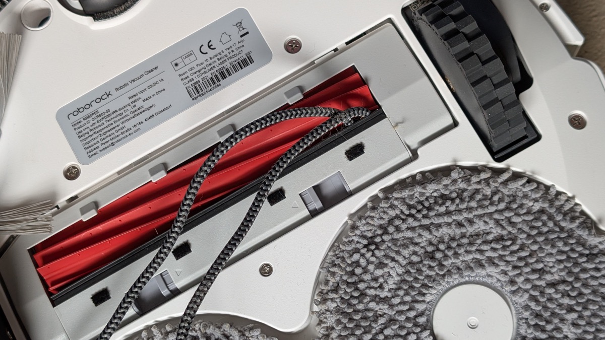 Câble enroulé dans la brosse d’aspiration sous le robot Roborock QV 35A