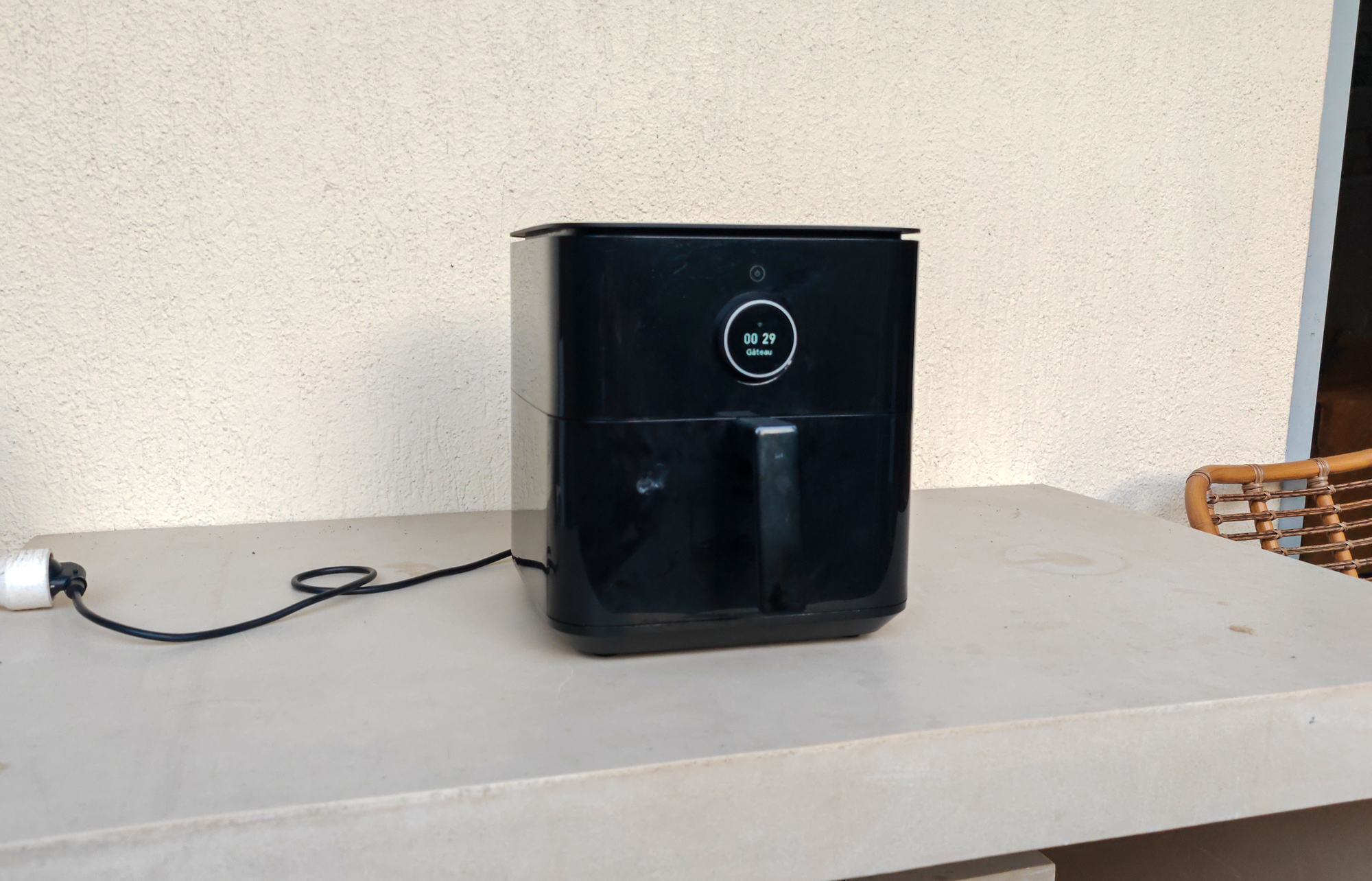 Airfryer posé sur un balcon, branché à une rallonge électrique extérieure