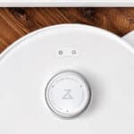 Balise alt : Robot aspirateur Roborock vu de dessus sur un parquet en bois