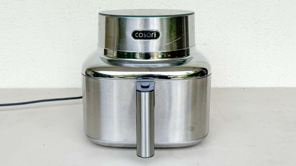 Airfryer posé sur une table de terrasse en extérieur pour cuisiner pendant l'été