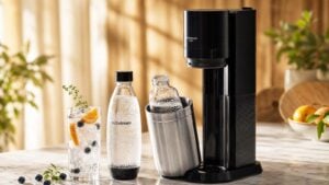 Machine à soda SodaStream Duo avec bouteilles réutilisables et verre d'eau gazeuse aux fruits frais sur comptoir cuisine été 2026
