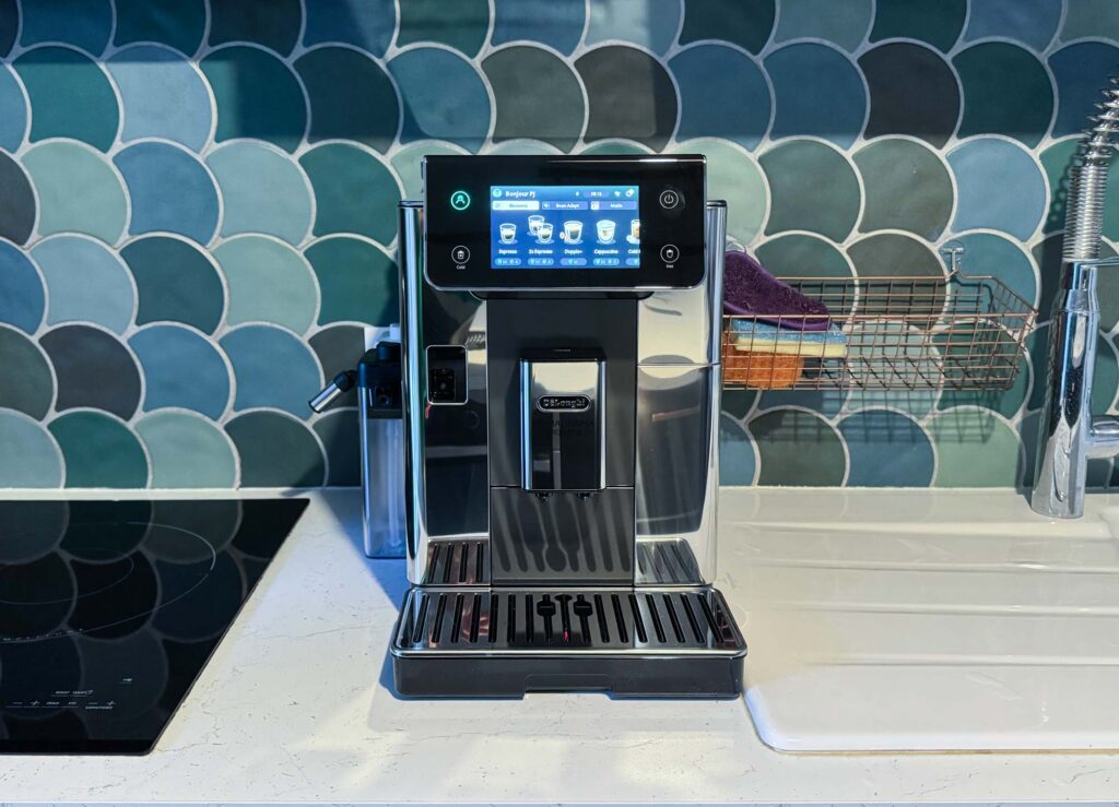 Machine à café Delonghi PrimaDonna Aromatic posée sur un plan de travail en cuisine