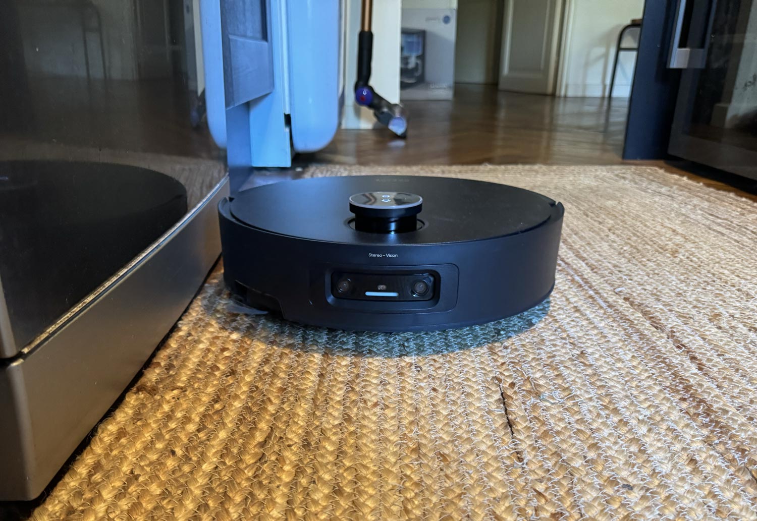 Robot aspirateur-laveur en train d’aspirer un tapis épais.