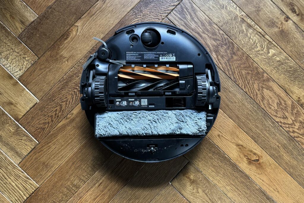 Vue du dessous du robot montrant la bouche d’aspiration et le système de lavage à chenille.