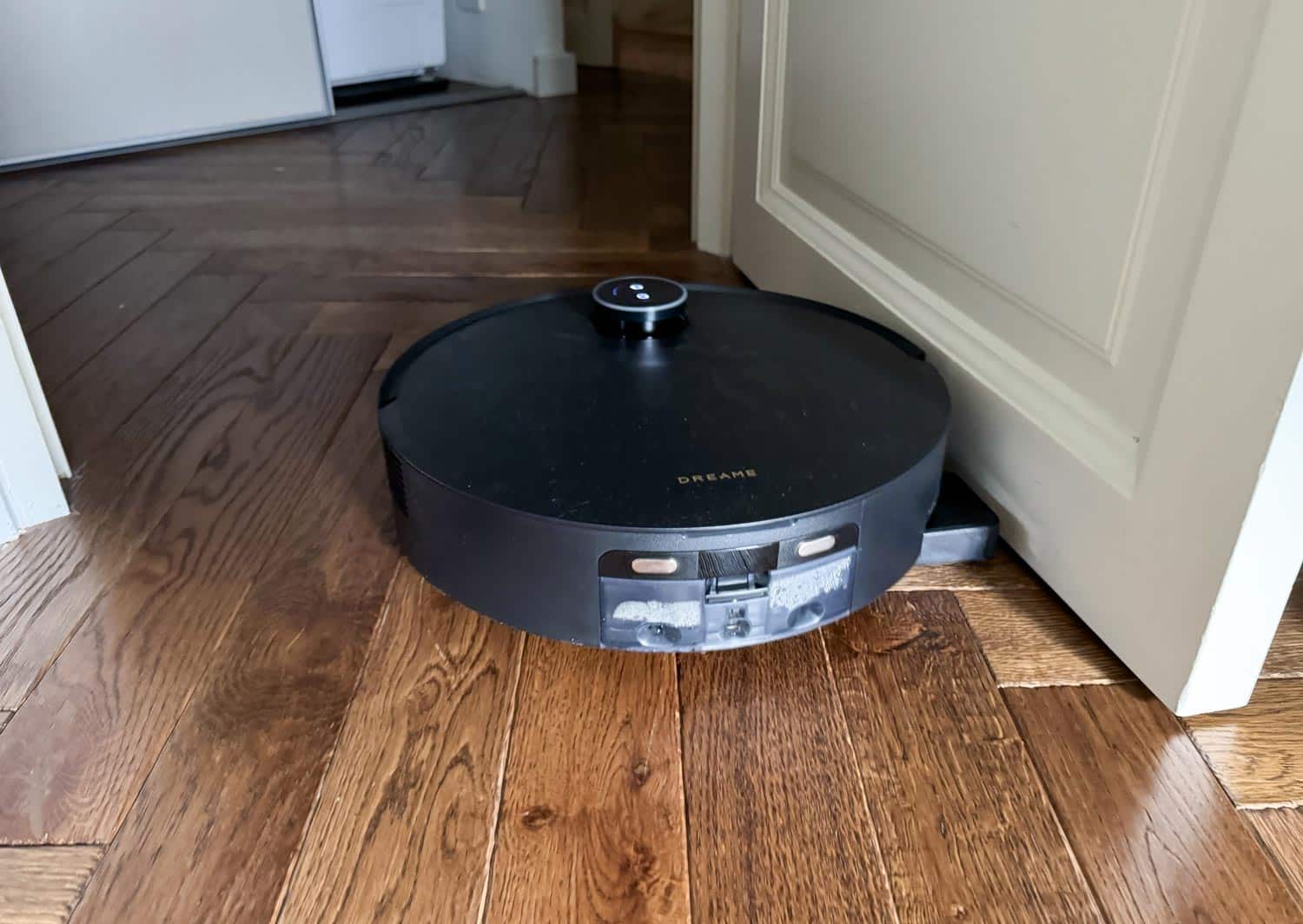 Robot laveur effectuant un lavage déporté près d’une plinthe.