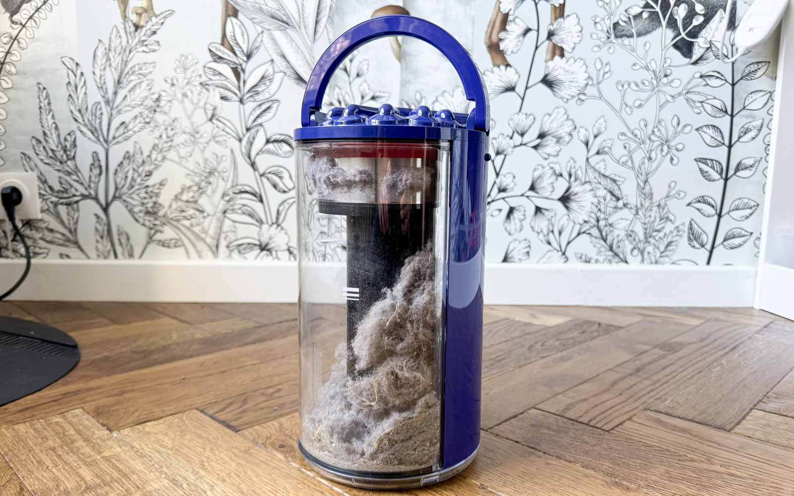 Collecteur cyclonique sans sac de la station du Dyson Spot+Scrub Ai avec poussières visibles