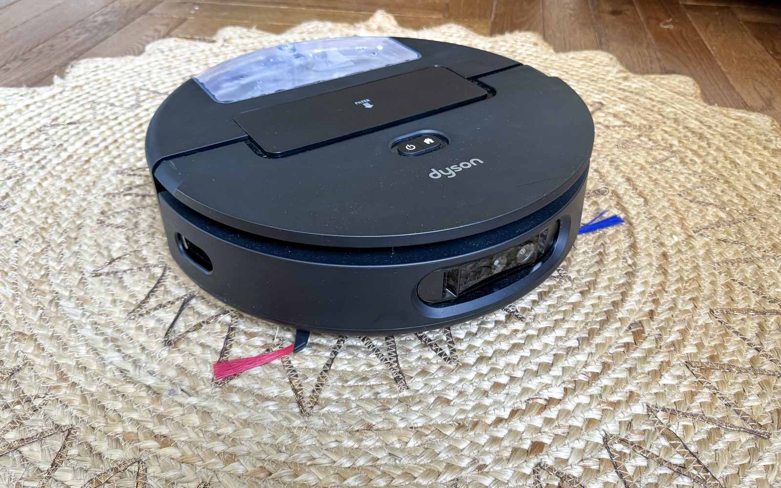 Robot aspirateur laveur Dyson Spot+Scrub Ai aspirant un tapis avec rouleau relevé