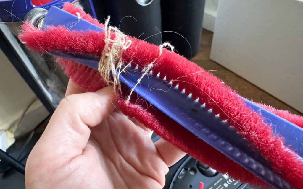 Brosse d’aspiration du Dyson Spot+Scrub Ai avec cheveux et poils enroulés autour de l’axe