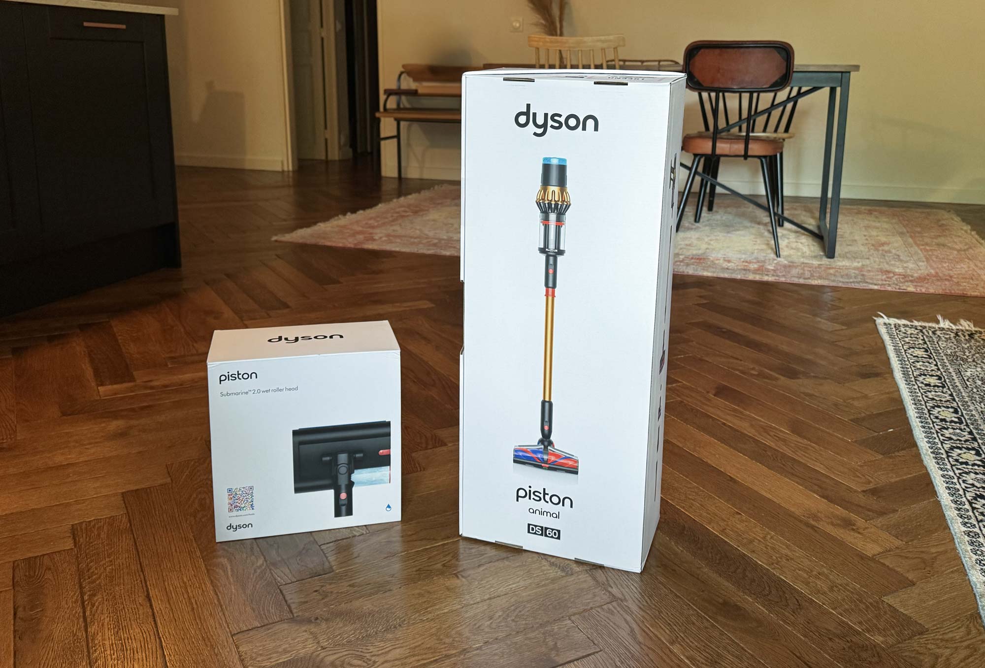 Cartons du Dyson V16 Piston Animal et de la brosse Submarine posés sur un parquet