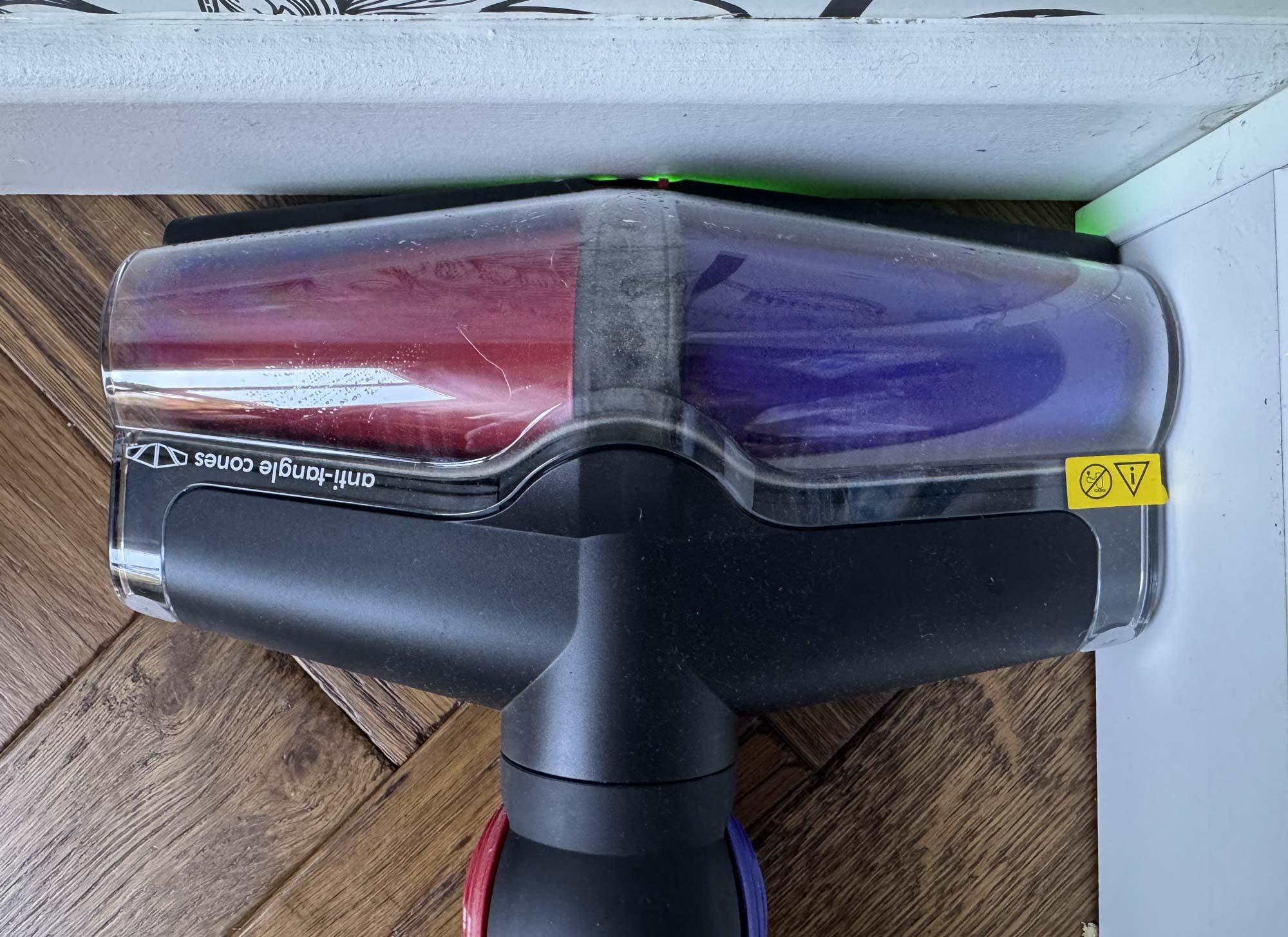 Brosse All Floors Cones du Dyson V16 légèrement en V contre une plinthe