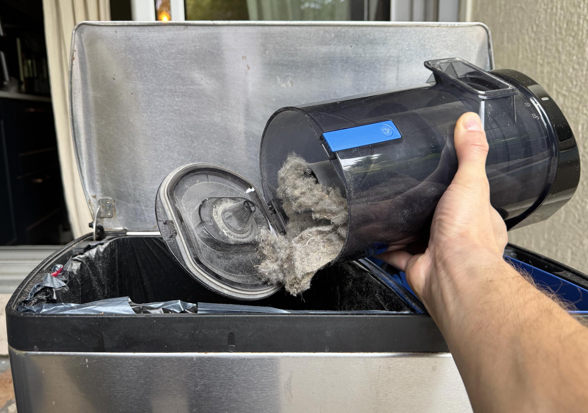 Vidange manuelle du collecteur sans sac de la station du Ecovacs Deebot X11 dans une poubelle