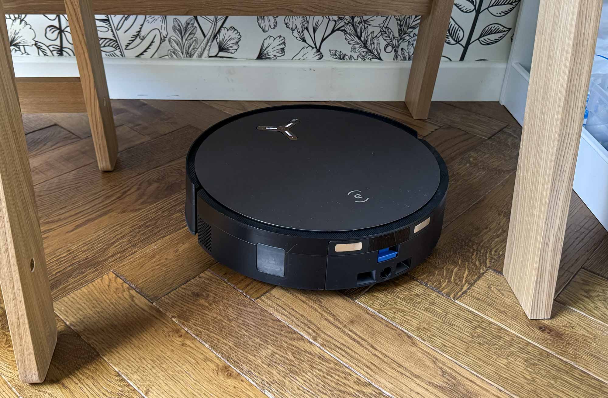 Ecovacs Deebot X11 naviguant entre un pied de table et une chaise