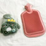 Deux bouillottes à eau sur un lit, symbole du confort hivernal mais aussi des risques de brûlures en cas de mauvaise utilisation