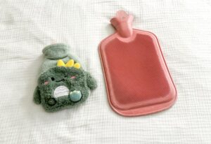 Deux bouillottes à eau sur un lit, symbole du confort hivernal mais aussi des risques de brûlures en cas de mauvaise utilisation