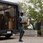 Figure 03 en train de décharger des cartons dans un véhicule