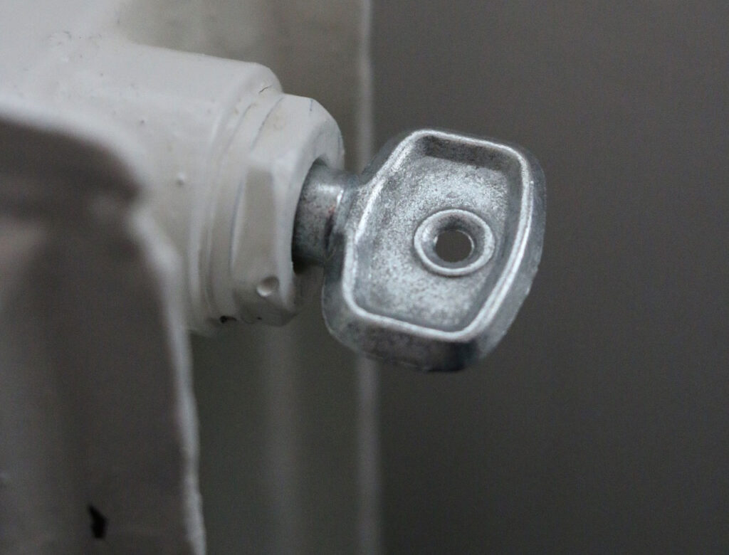 Radiateur avec clé de purge utilisée pour évacuer l’air du circuit de chauffage.