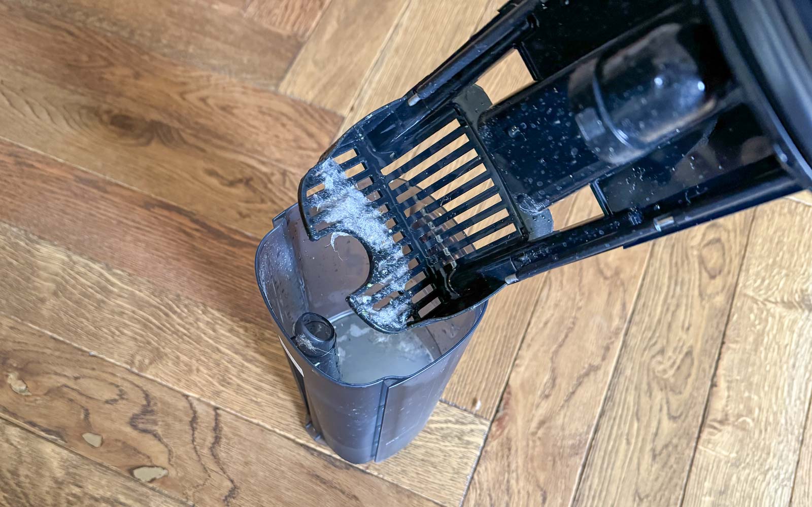Bac d’eau sale du Roborock F25 Ultra ouvert avec filtre et résidus après nettoyage