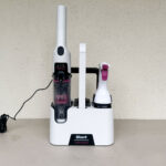 Shark StainForce HX100EUT posé sur son socle autonettoyant avec ses produits Shark