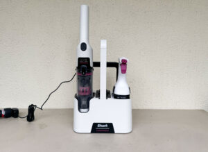 Shark StainForce HX100EUT posé sur son socle autonettoyant avec ses produits Shark