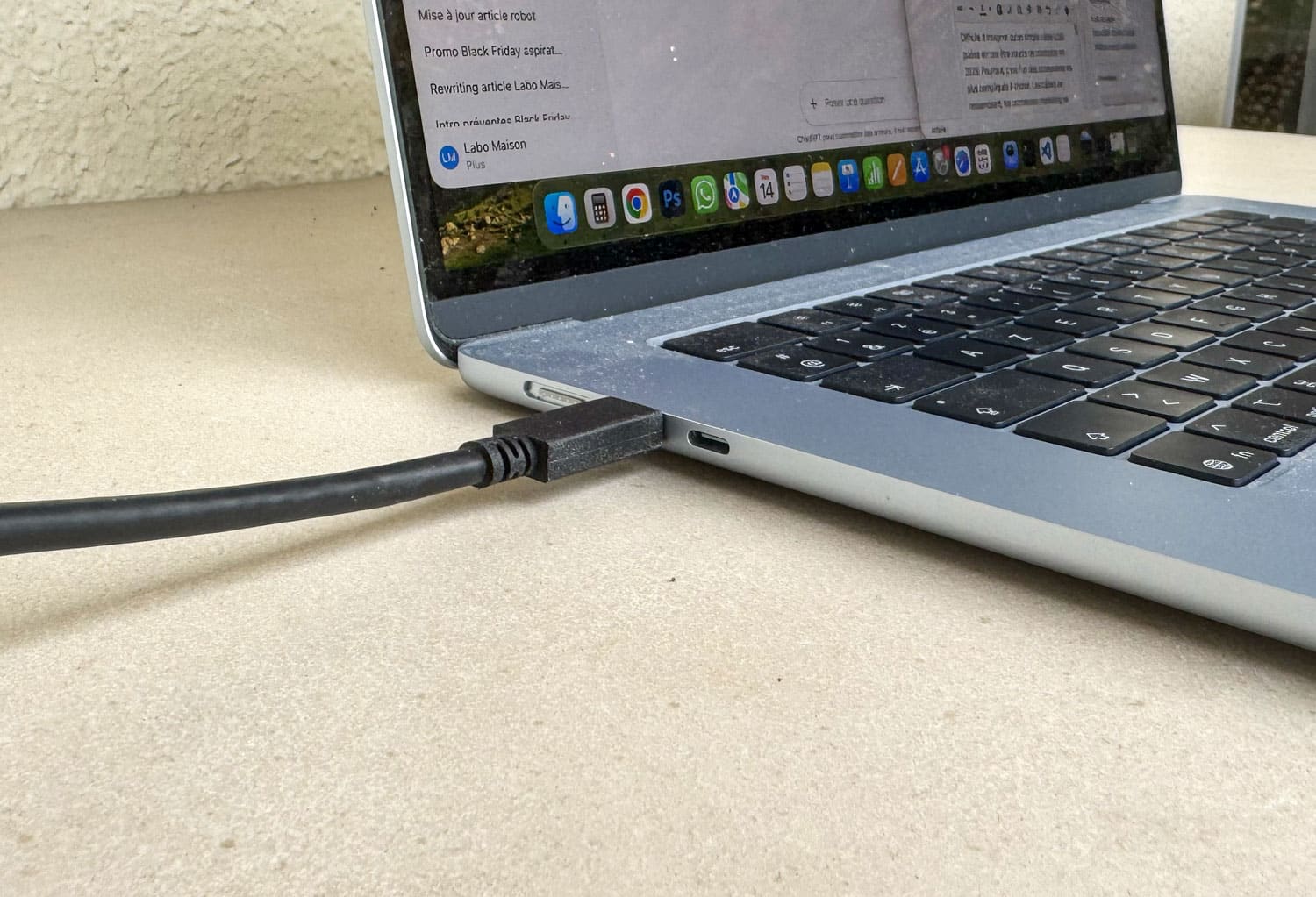 Gros plan d’un câble USB-C branché sur un ordinateur portable en charge