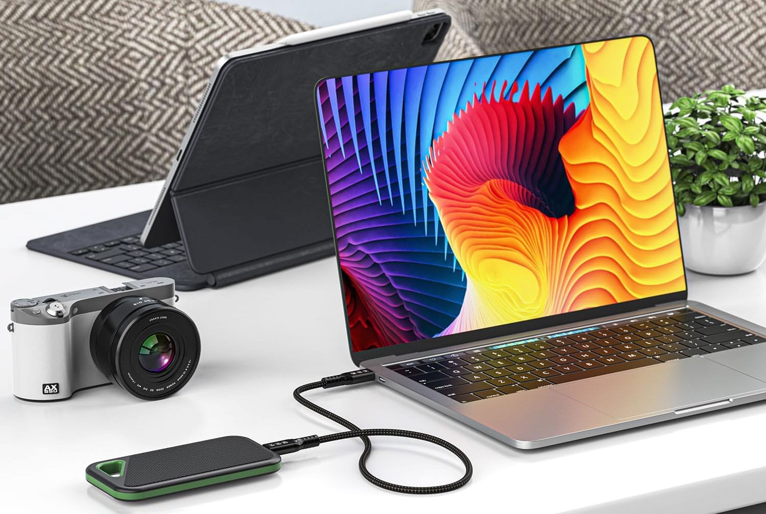 Ordinateur portable connecté à un écran 4K, un disque SSD externe et une station d’accueil via un câble Thunderbolt