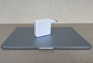 Chargeur Apple 96 W posé sur un MacBook Air 15 pouces pour illustrer sa taille