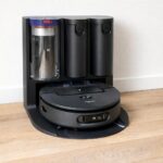 Robot aspirateur laveur Dyson Spot+Scrub AI installé sur sa station de nettoyage automatique