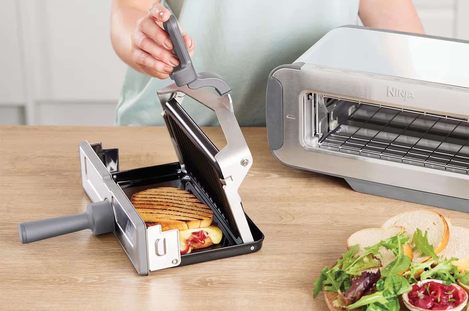 Grille-pain Ninja Foodi 3‑en‑1 en mode panini, en train de presser un croque-monsieur
