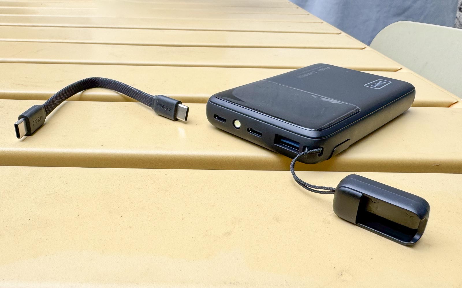 Vue de la connectique de la batterie Iniu Slim : ports USB-C, USB-A et dragonne amovible faisant office de câble de charge