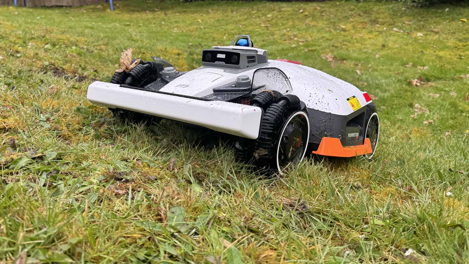 Robot tondeuse Mammotion Luba 3 AWD 4x4 en train de grimper une pente raide en utilisant ses suspensions indépendantes.