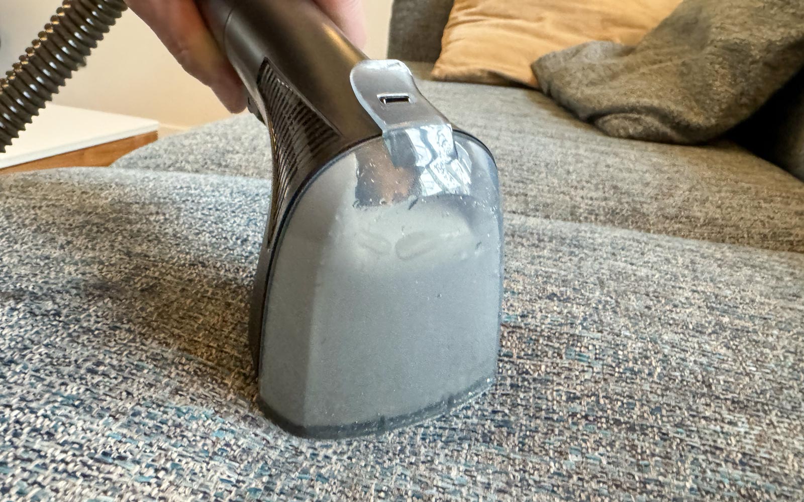 Tête d’aspiration du Rowenta Clean It Compact sur un canapé