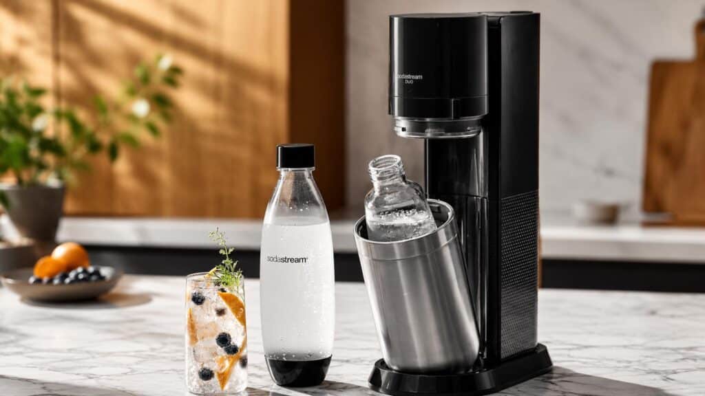 SodaStream Duo posée sur un plan de travail de cuisine avec bouteilles d’eau pétillante