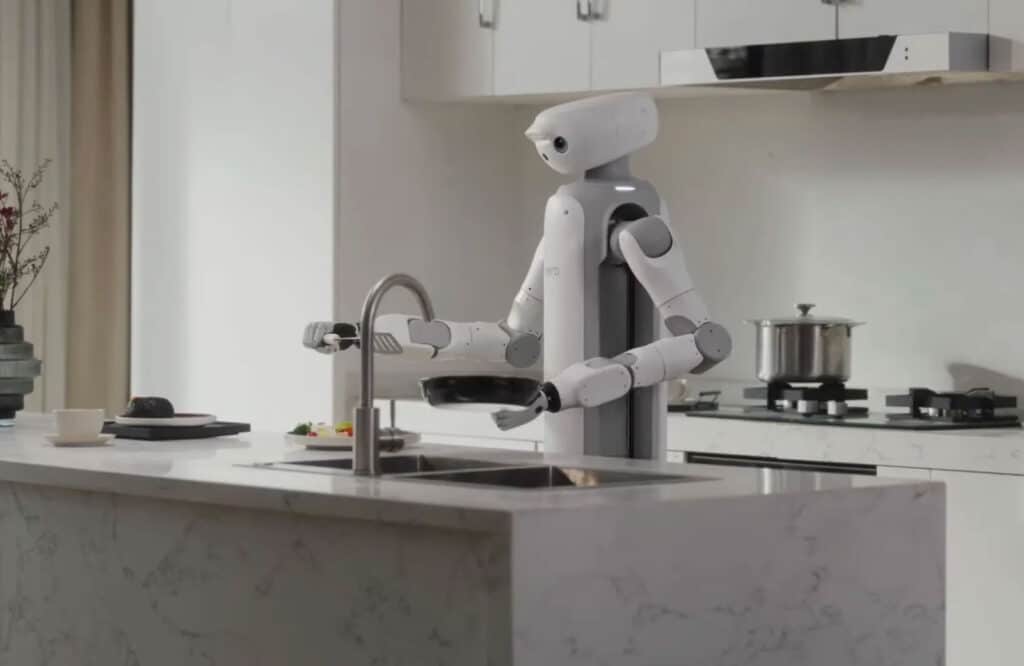 Robot domestique SwitchBot Onero H1 utilisant ses bras articulés pour manipuler des objets sur un plan de travail, comme des tasses ou du linge.