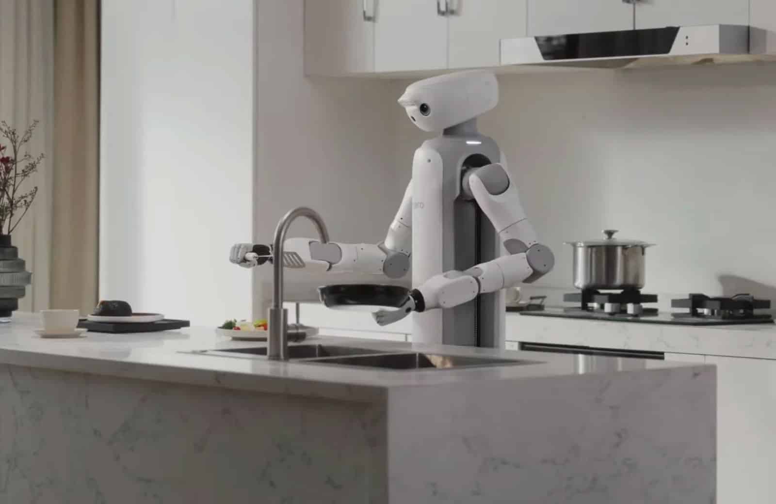 Robot domestique SwitchBot Onero H1 utilisant ses bras articulés pour manipuler des objets sur un plan de travail, comme des tasses ou du linge.