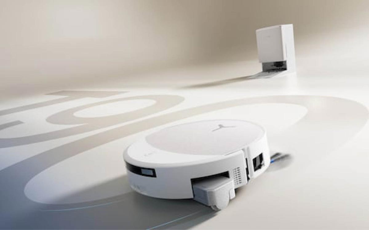 Le robot aspirateur-laveur Ecovacs Deebot T90 Pro Omni posé devant sa station multifonction, avec les bacs et fonctions d’entretien intégrés