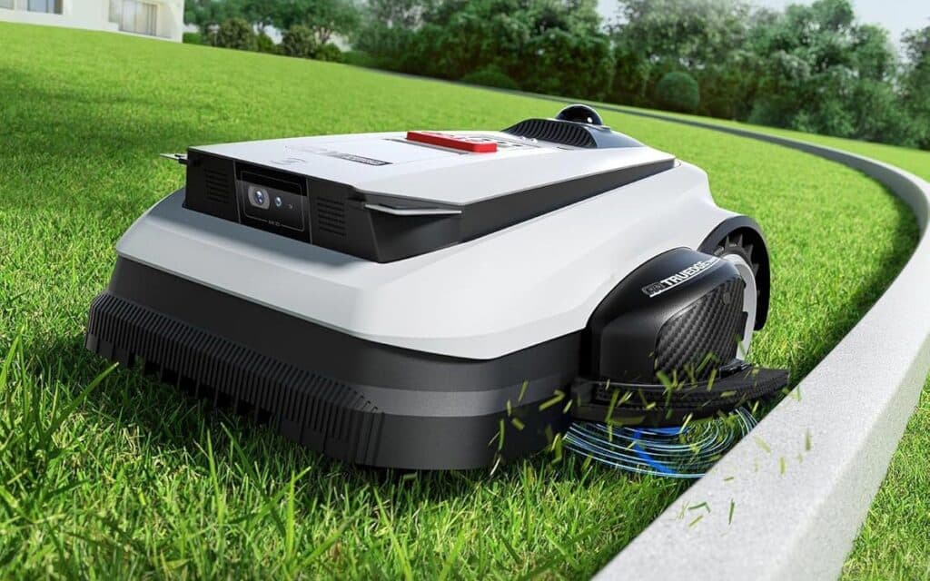 Robot tondeuse ECOVACS TruEdge coupant l'herbe au ras d'une bordure de jardin.