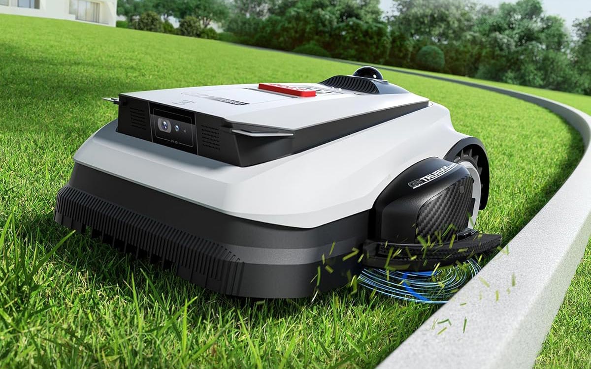 Robot tondeuse ECOVACS TruEdge coupant l'herbe au ras d'une bordure de jardin.