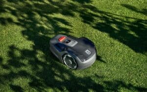 Robot tondeuse autonome Husqvarna Aspire R4 tondant une pelouse de jardin urbain.