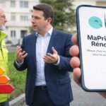 MaPrimeRénov’ affichée sur un smartphone, avec l’étiquette énergie et un échange avec un conseiller en arrière-plan.